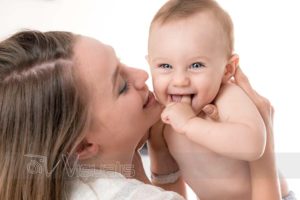 primo piano bambino occhi azzurri in braccio a mamma